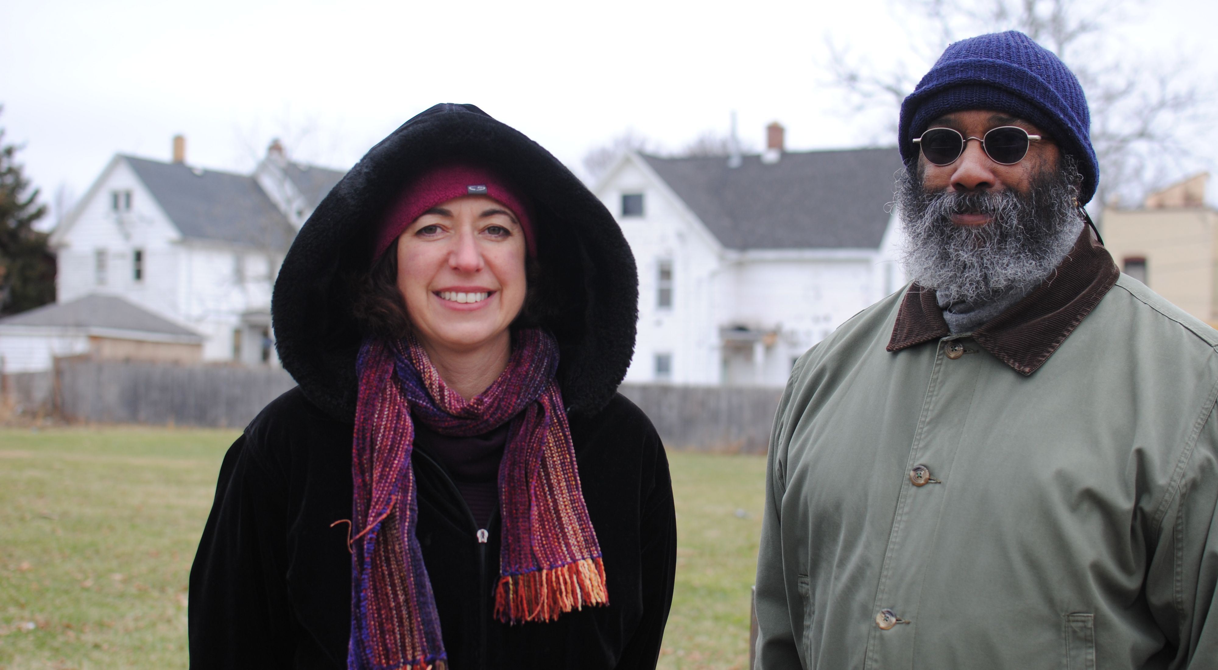two people standing in cold weather, a woman with a scarf, a man in a blue hat