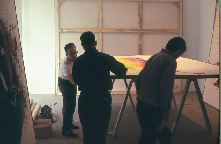 3 people stretching a painting