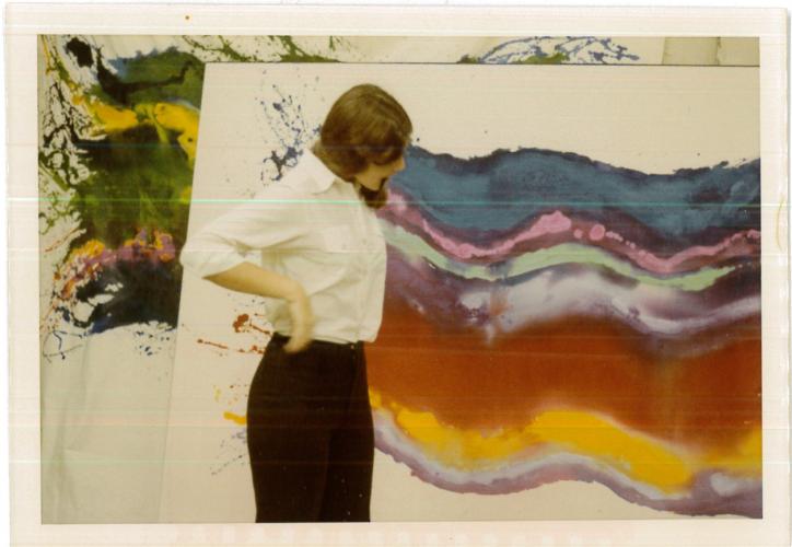 woman in front of a wave painting