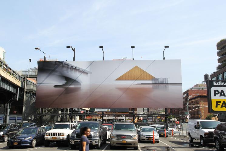 A view of a billboard with triangles and a photograph on it above a parking lot near the highline, nyc