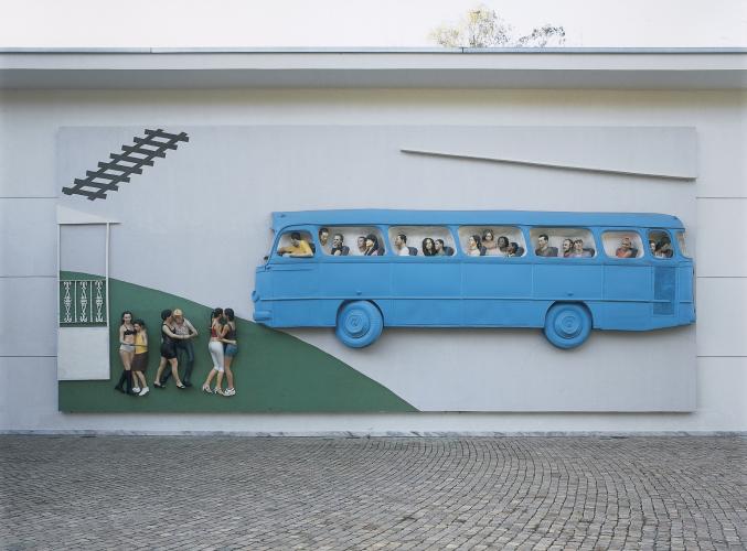 outdoor sculpture relief of a bus and people walking towards it