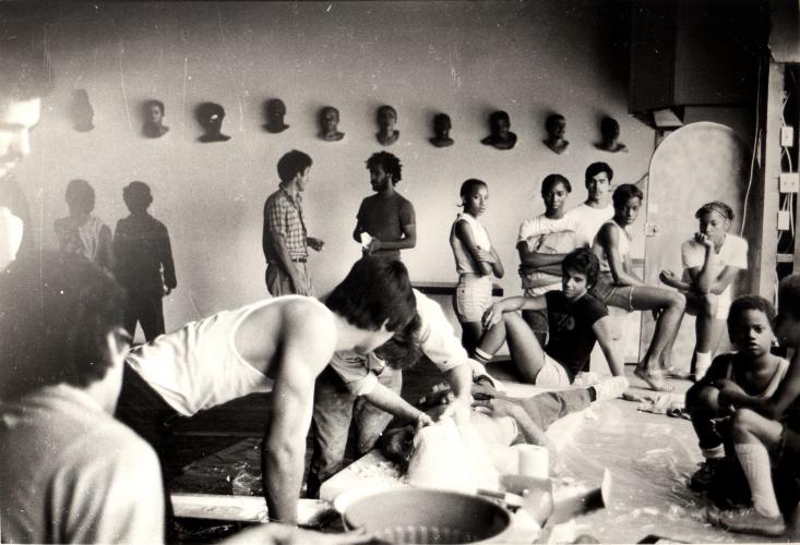 many people in a room preparing to cast bodies for sculptures