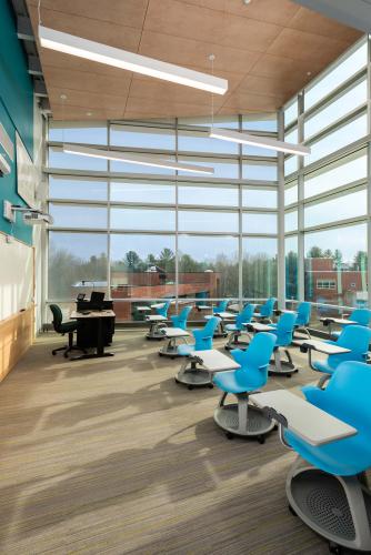 Inside a classroom with bright blue chairs and floor-to-ceiling windows
