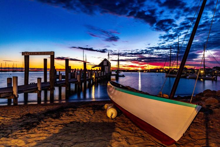 A boat sits on a beach after sunset