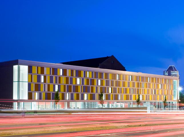 Library exterior consisting of all windows on the lower level and asymmetrical tiles in primary colors on the upper levels.