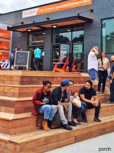 People gather on the porch outside Open Works.