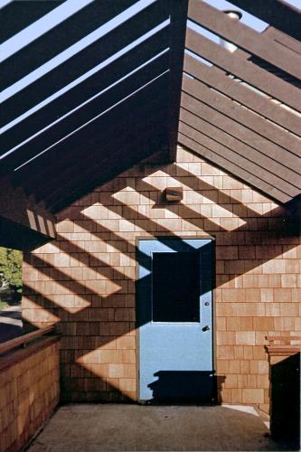 Roof beams cast a shadow across a door on the upper deck.