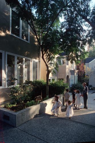 An adult children walk through a courtyard link.