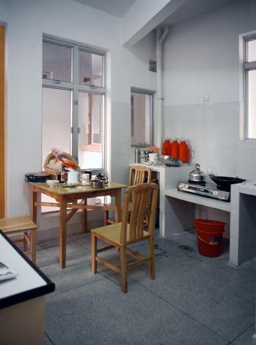 Small square table and chairs next to small counters with kitchen appliances in a dorm room.
