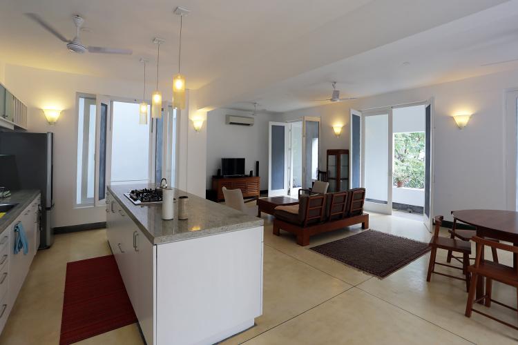 An open kitchen and living room open to a small balcony.