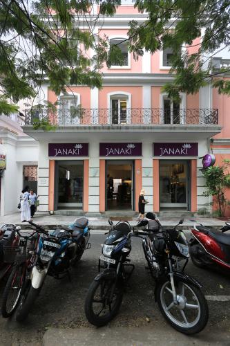 Motor bikes parked outside a coral-colored building.