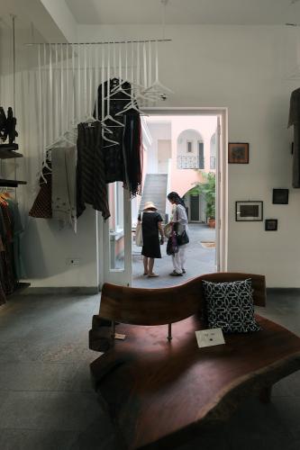 Clothing hang next to a doorway that opens into the courtyard.