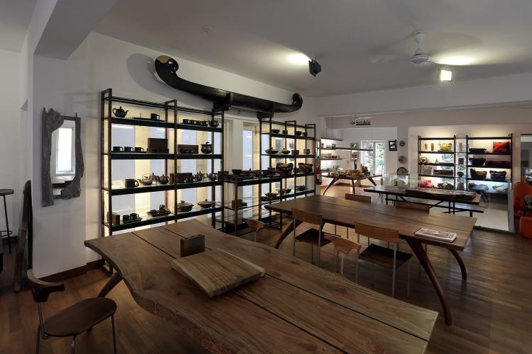 The mezzanine floor features wooden tables and shelves of pottery.