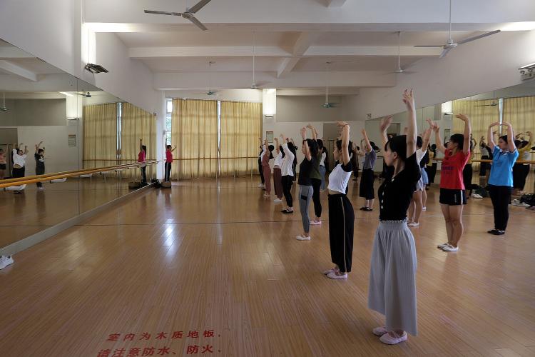 Students hold a dance pose in a studio.