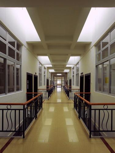 A long hallway is lined symmetrically with railings and windows.