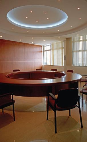 A wooden, donut-shaped table fills a conference room.