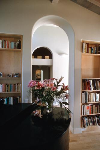 A vase of pink flowers on a table in the library.