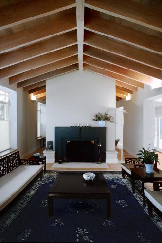 Two chairs face a coffee table and bench in a living room.