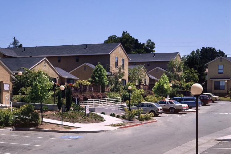 Cars are parked outside homes in community housing complex.