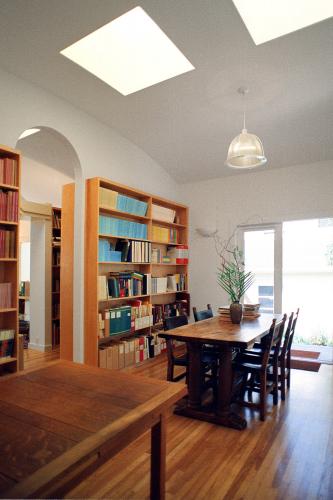 A table and chairs in front of a bookshelf in the home library.