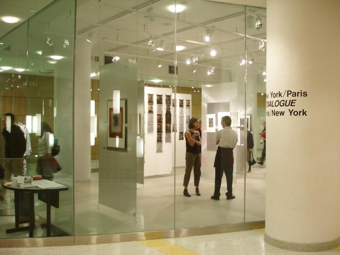 Adults browse an art exhibition at a museum. 