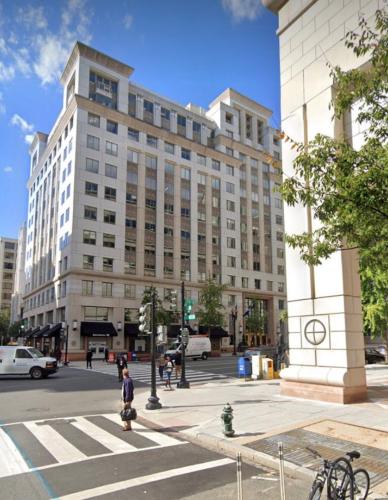 A white and tan building overlooks an intersection.