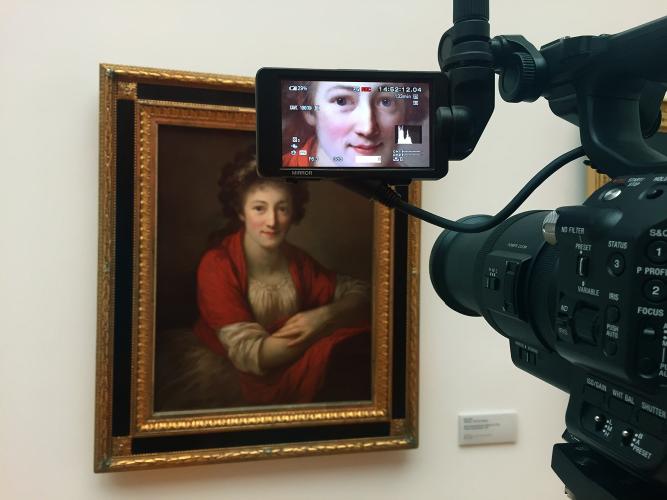A video camera is filming in an art museum.
