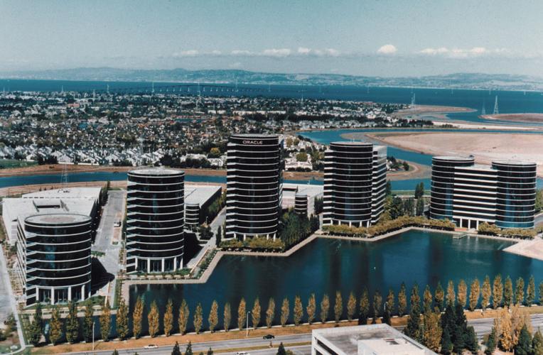 Aerial view of tall buildings surrounding a large pool that's shaped somewhat like a sunburst. 