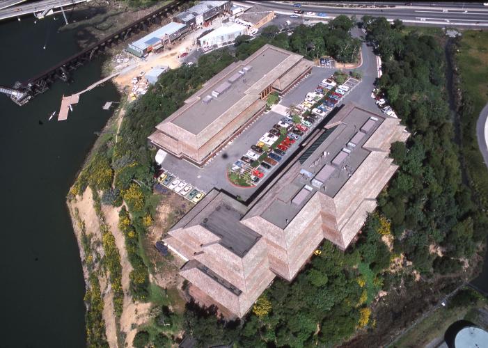 Aerial view of a two-building complex and rooftop garage on a hilltop site.