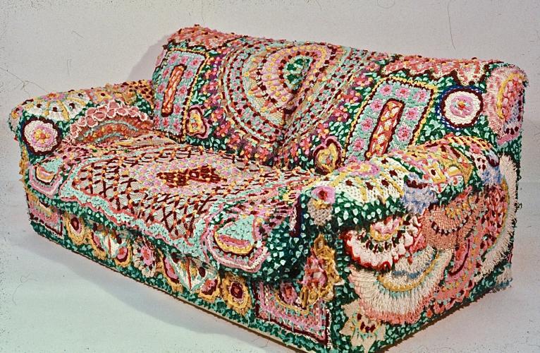 Sideview of colorful couch with doily motifs.