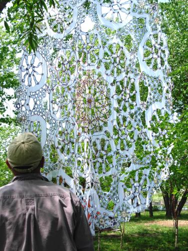 Closeup view of large doily suspended in the air outside