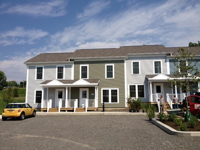 Front view of four attached homes with neutral-colored siding.