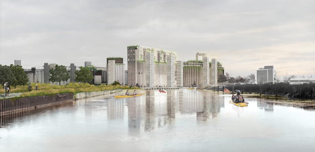 View of kayakers padding toward a building overlooking the water.