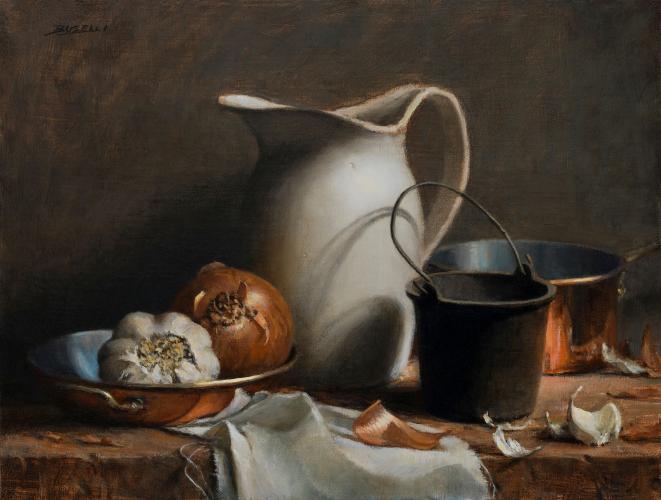 A still life display consisting of a bulb of garlic and an onion in a copper pan, a white pitcher, a small black pot, and a copper cooking pot, with stray garlic and onion peels, on a table. 