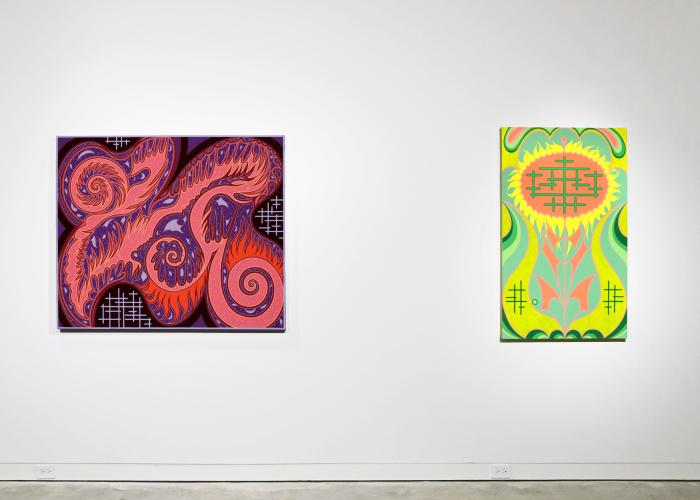 Two colorful, abstract paintings adorn a wall in a gallery.
