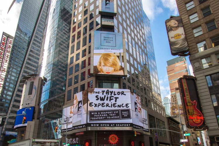 Digital billboards in NYC advertise the Taylor Swift Experience.