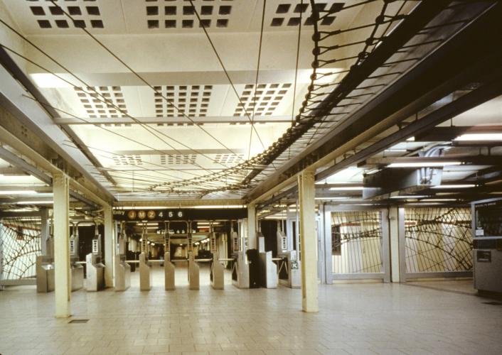 Barricade fence units hang overhead at a New York City subway station as a tribute to the Brooklyn Bridge.