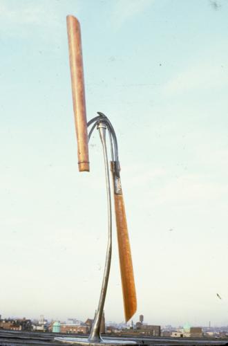 A 14-foot kinetic wind sculpture made of galvanized steel, wood columns, and bearings, based on the Savonius rotor vertical axis windmill.