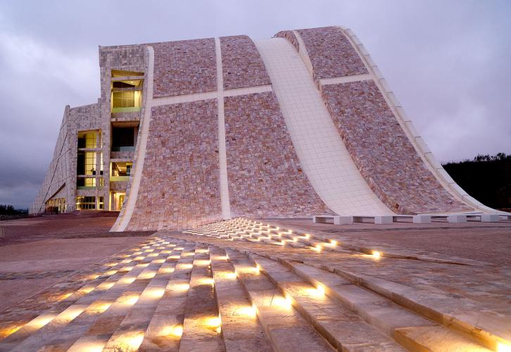 Detail view of a tiled structure curving upward like a hill.