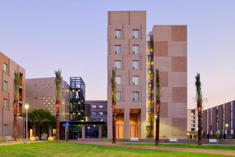 An entrance sandwiched between two towers on the right and a squatter multifloored building on the left.