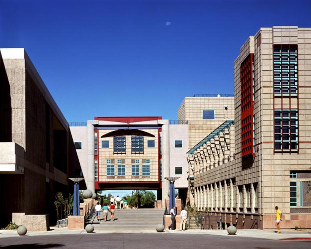 A skywalk bridge connects two buildings, while crossing over a pedestrian pathway.