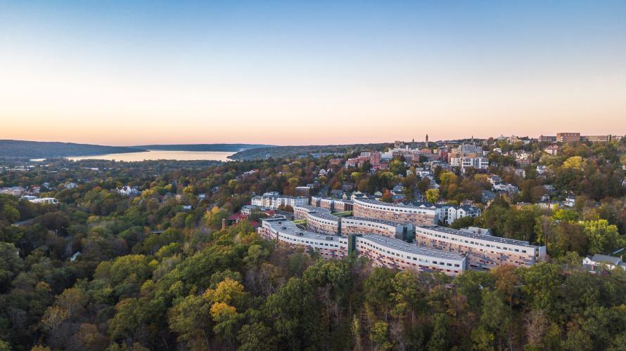 Aerial view of buildings on a hill overlooking a lake in the distance.