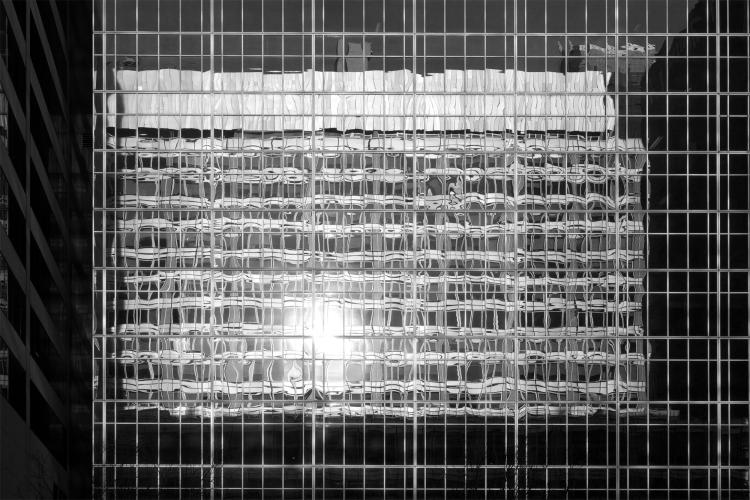 A grided glass building facade reflects another grided glass facade