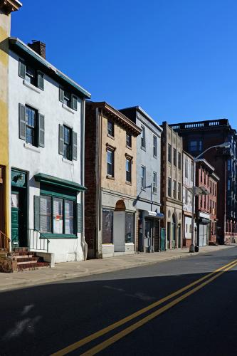 Photograph of worn, vacant rowhouses along an empty street.