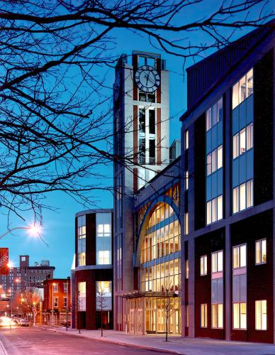 Street-level view of a building's main entrance and front facade's window wall.