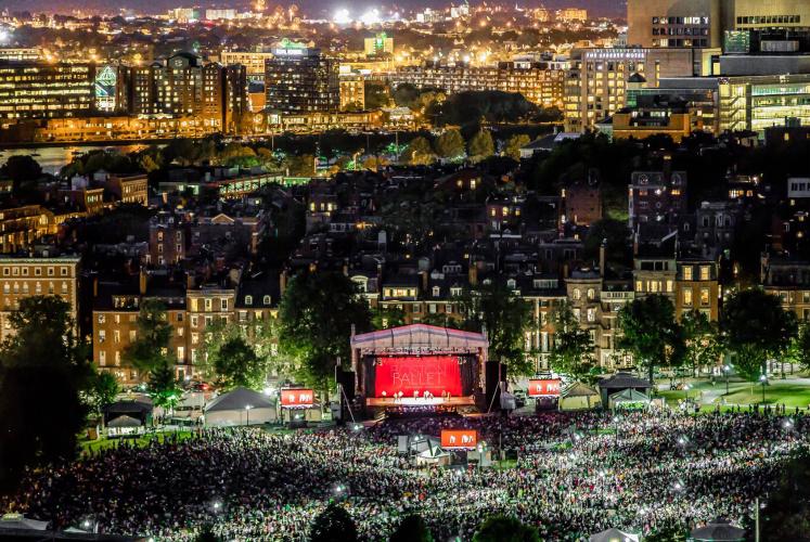 An aerial photo of an outdoor stage for a ballet performance and a large audience at night